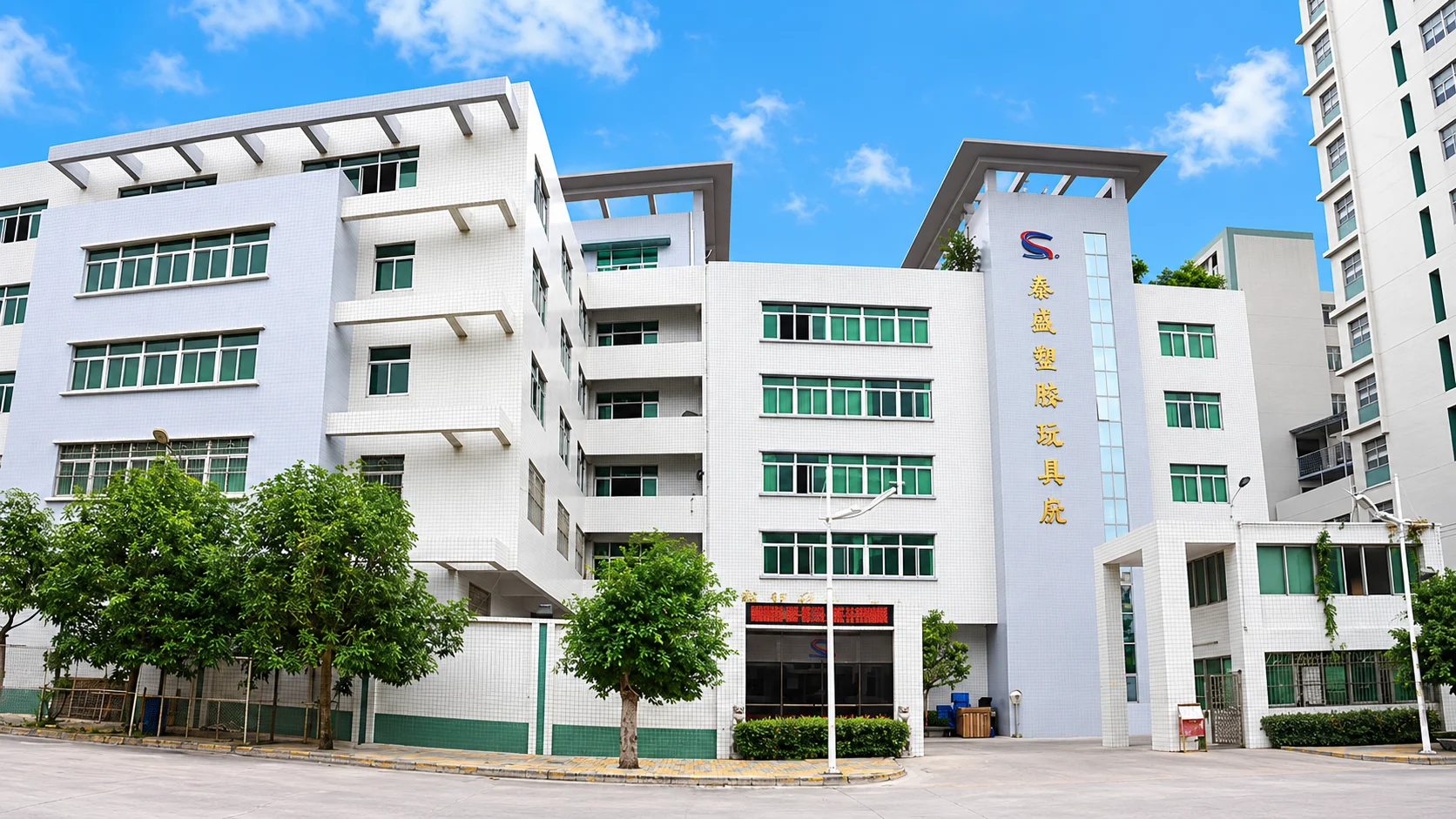 Taisheng Toy Factory's white buildings, green windows and main entrance in Chenghai